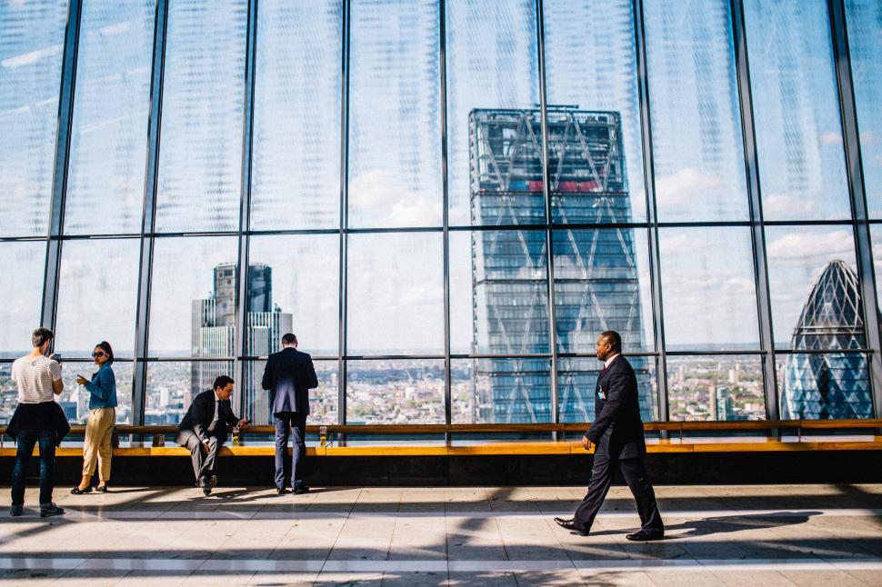 Free Image of Group of People Standing in Front of Large Window 