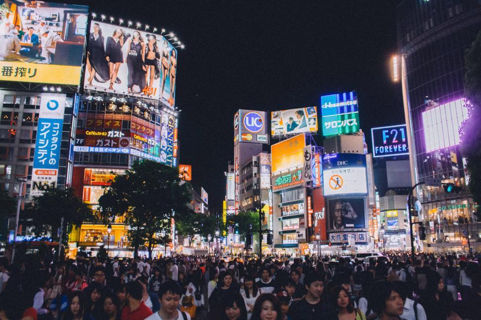 Free Image of Crowd of People Walking Down a Street at Night 