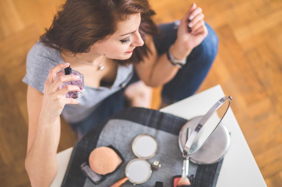 Free Image of Woman Sitting at Table Holding Magnifying Glass 