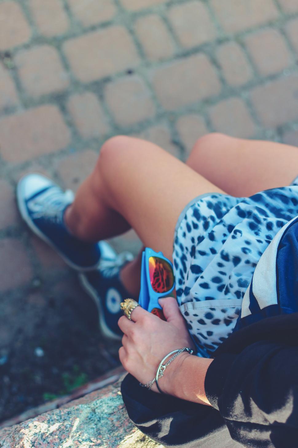 Free Image of Woman Laying on Ground Holding Cell Phone 
