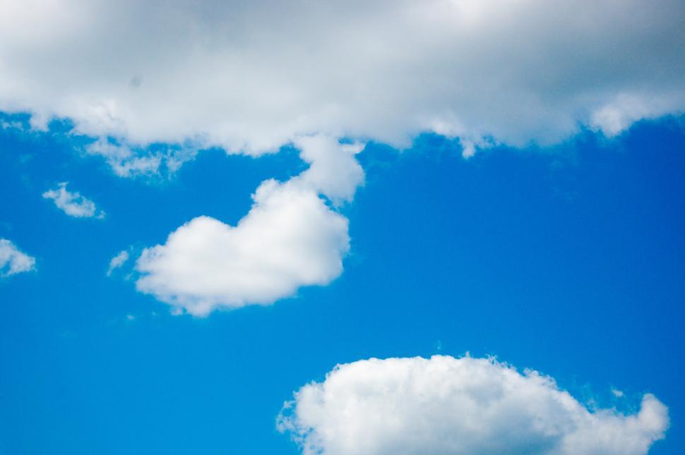 Free Image of Plane Flying Through Blue Cloudy Sky 