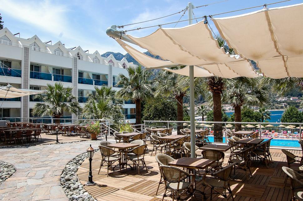 Free Image of Patio With Tables and Umbrellas by a Swimming Pool 
