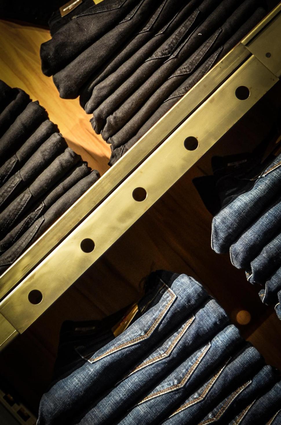 several-pairs-of-jeans-stacked-on-shel.jpg