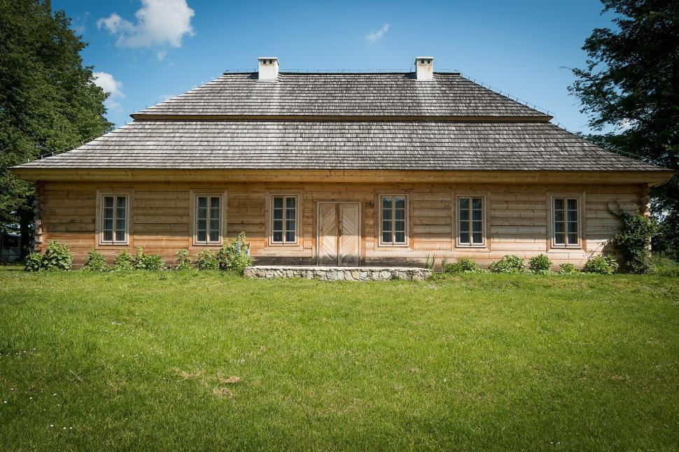 Free Image of Small Wooden House on Lush Green Field 