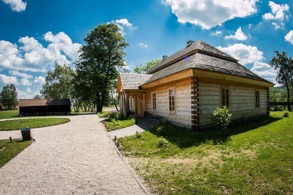 Free Image of Small Wooden Building on Lush Green Field 