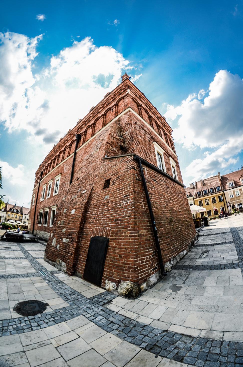 Free Image of Tall Brick Building Along Side of Road 