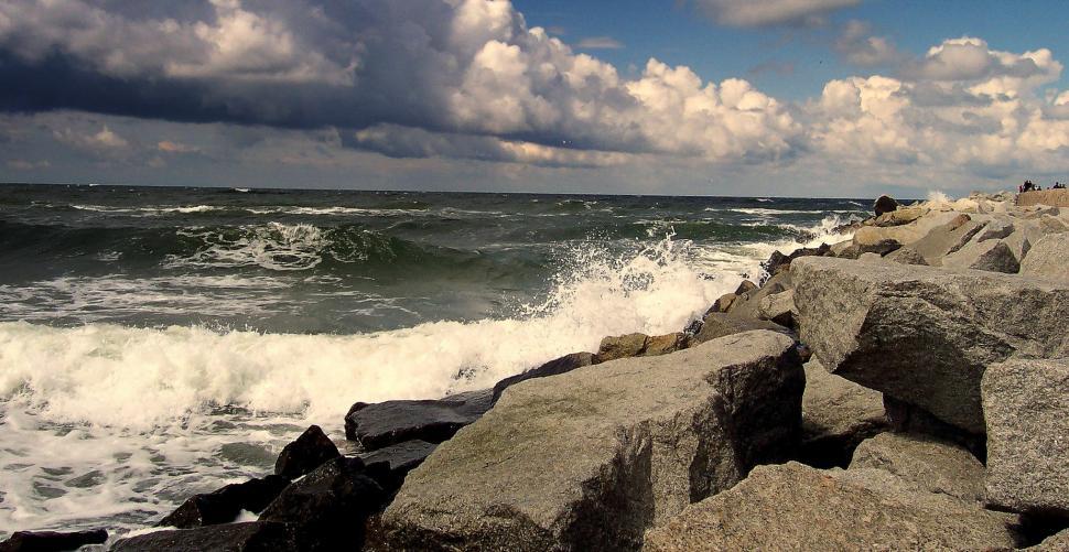 Free Image of Person Sitting on Rock Next to Ocean 