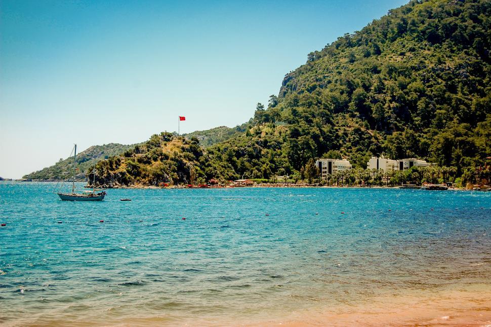 Free Image of Boat Sailing on Water by Hill 