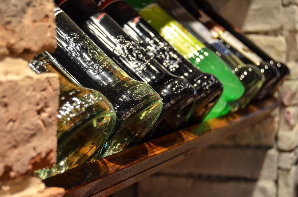 Free Image of Bottles of Beer Lined Up on Shelf 
