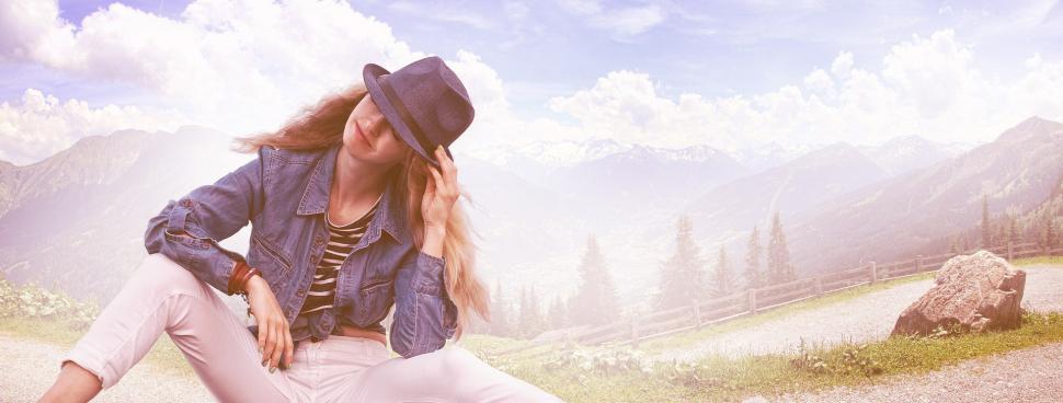 Free Image of Woman Sitting on Rock in Field 