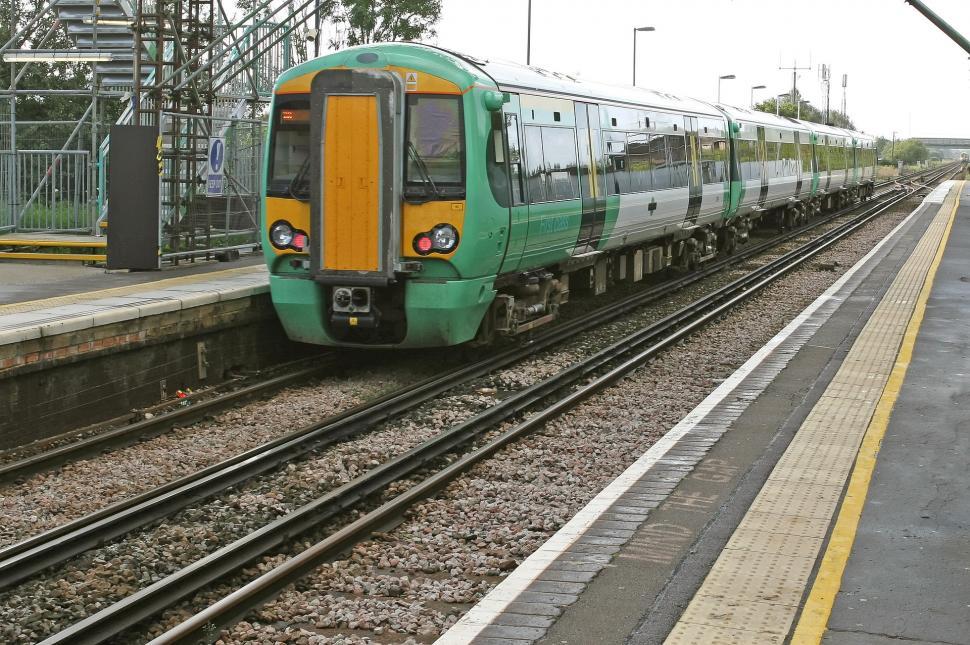 Free Image of Green and Yellow Train Traveling Down Train Tracks 