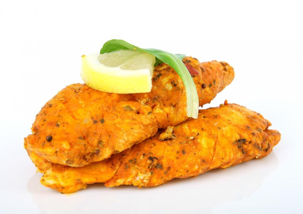 Free Image of A Pile of Chicken With a Lemon Wedge 