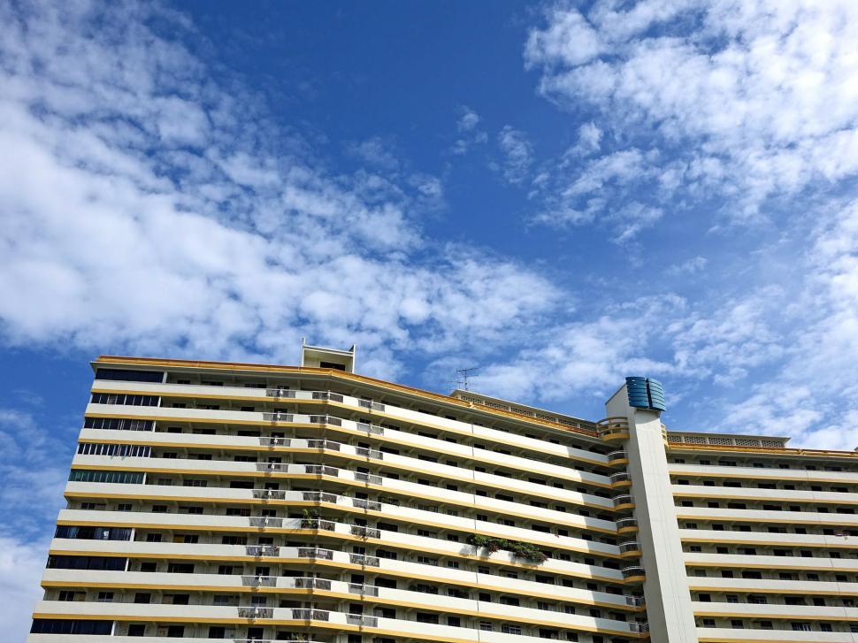 Free Image of Tall Building Under Cloudy Blue Sky 