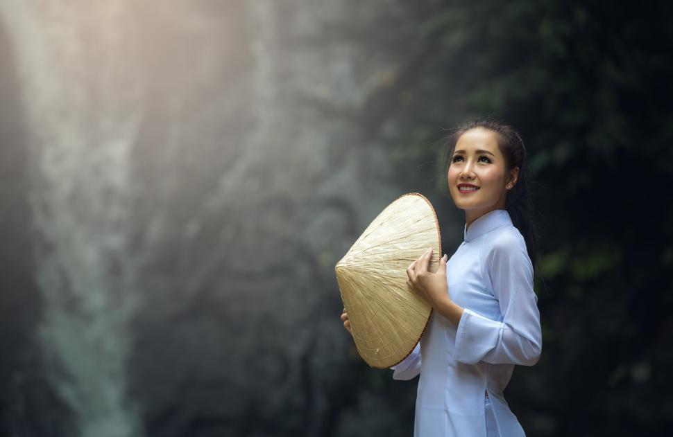 Free Image of Woman Holding Umbrella in Front of Waterfall 