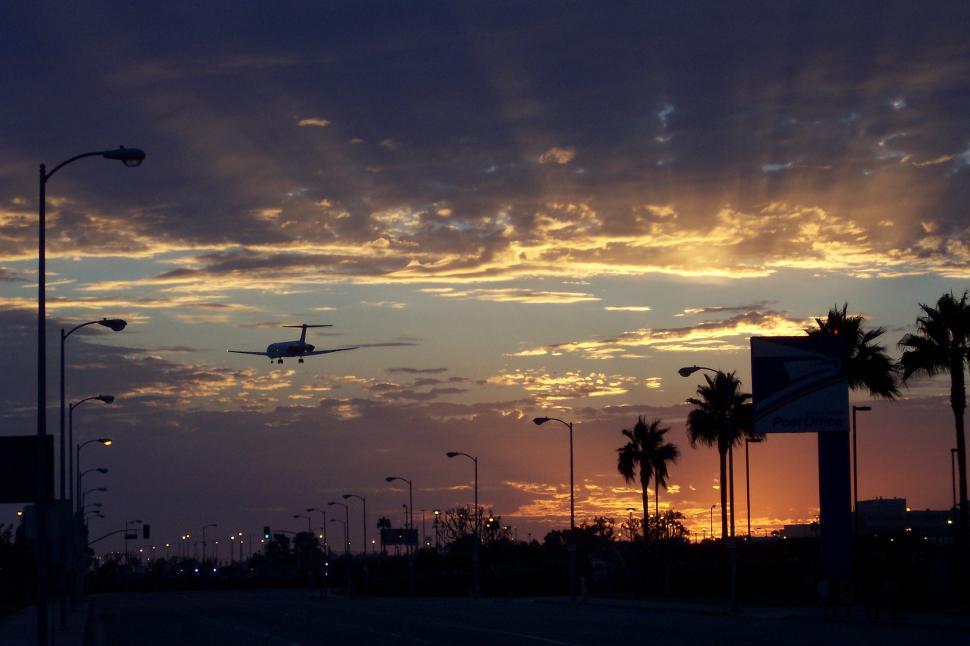 Free Image of A Plane Flying in the Sky at Sunset 