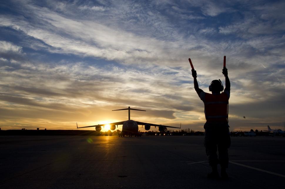 Free Stock Photo of Man Standing With Arms Raised in Parking Lot