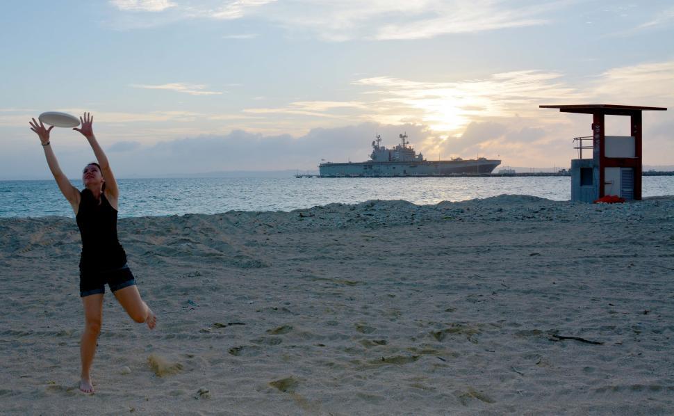 Free Image of Woman Playing Frisbee on Beach 