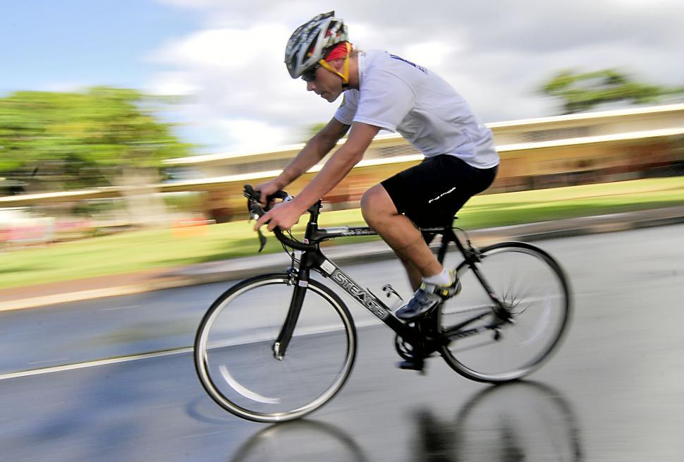 Free Image of Man Riding Bike Down City Street 