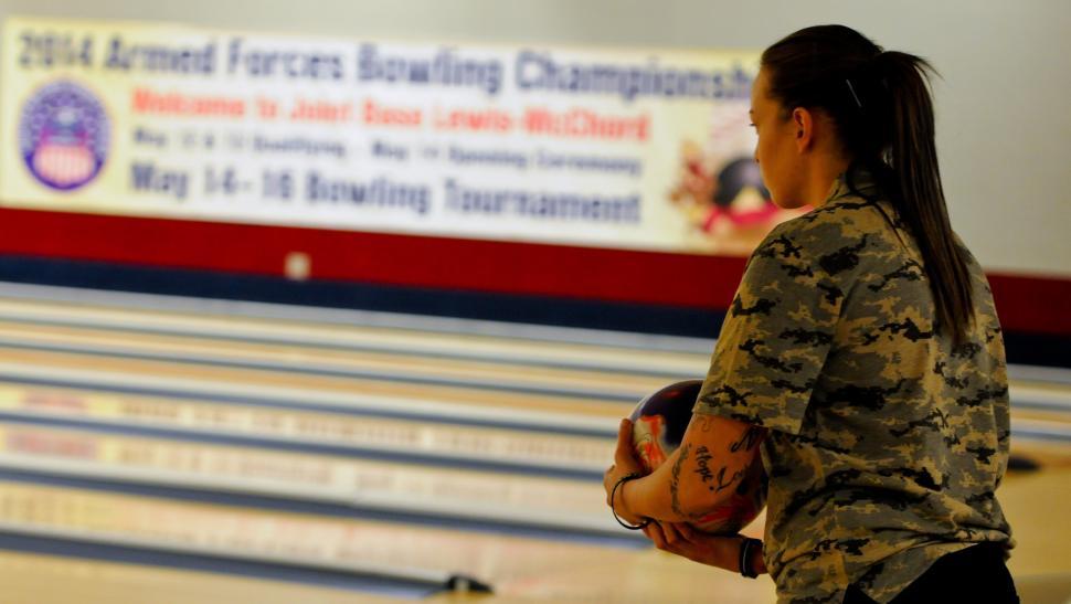 Free Image of Woman Holding Bowling Ball in Bowling Alley 