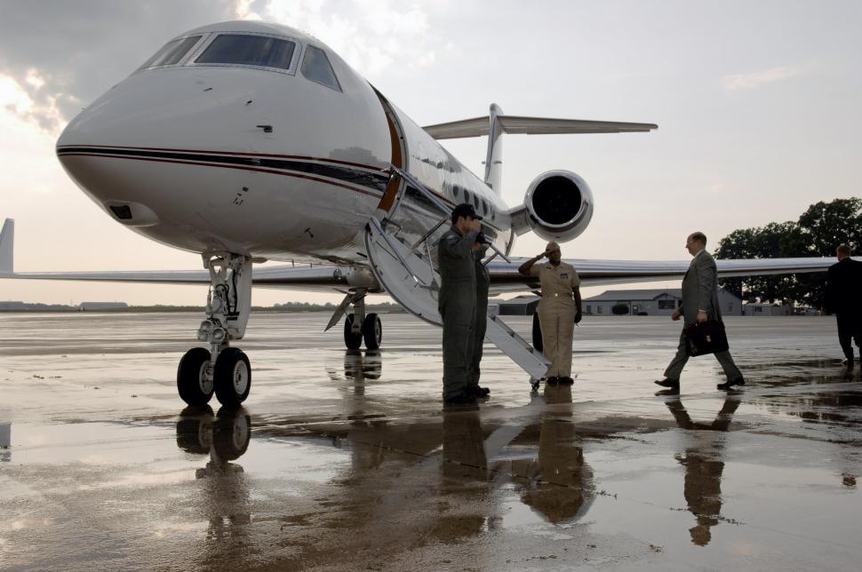 Free Image of Group of People Standing Next to an Airplane 