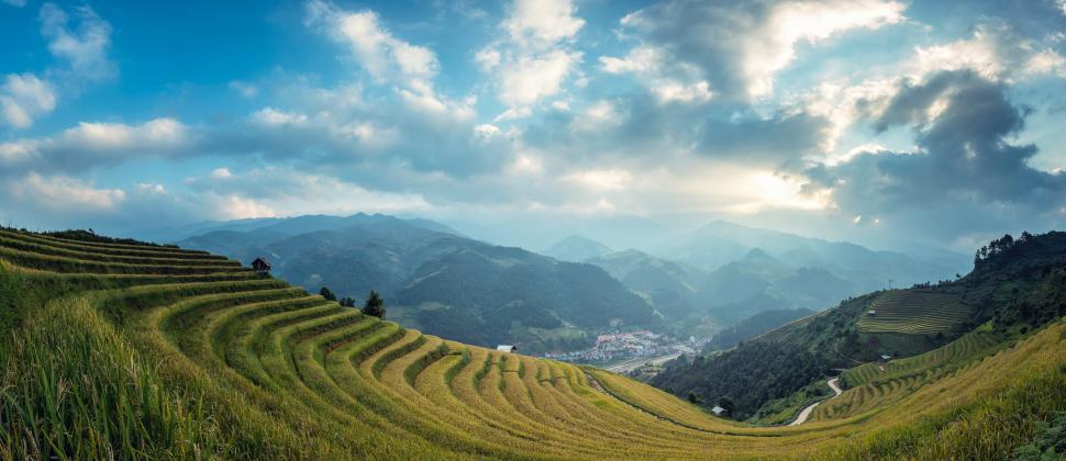 Free Image of Lush Grass Field With Majestic Mountains in Background 