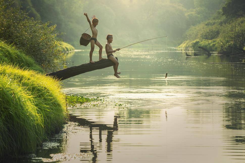 Free Stock Photo of Two Children Fishing on a Log in the Water