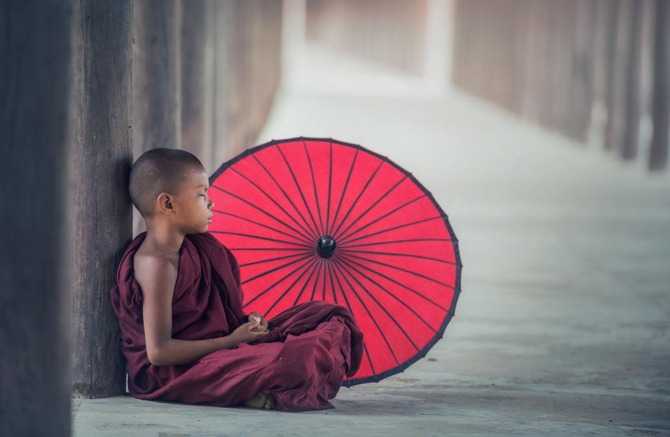 Free Image of Person Sitting on Ground With Red Umbrella 