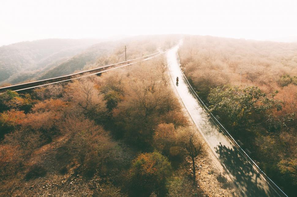 Free Image of Person Riding Bike Down Dirt Road 
