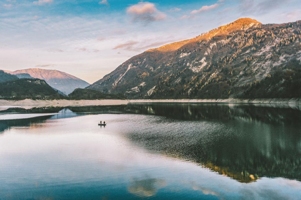 Free Image of Boat Floating on Lake Surrounded by Mountains 