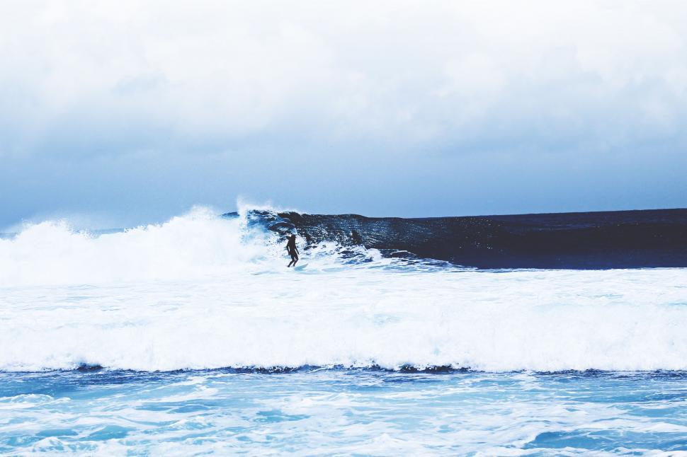 Free Image of Man Riding a Wave on Surfboard 
