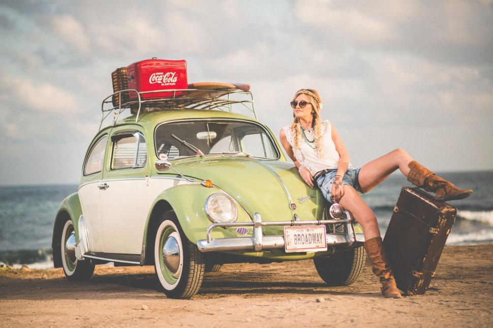 Free Image of Woman Sitting on Green Car by Ocean 