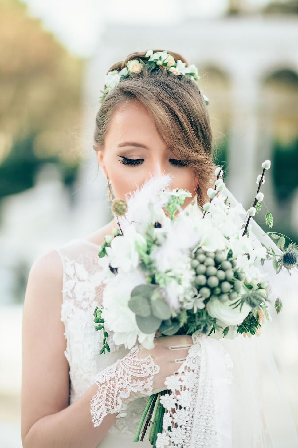 Free Image of Woman in Wedding Dress Holding Bouquet of Flowers 