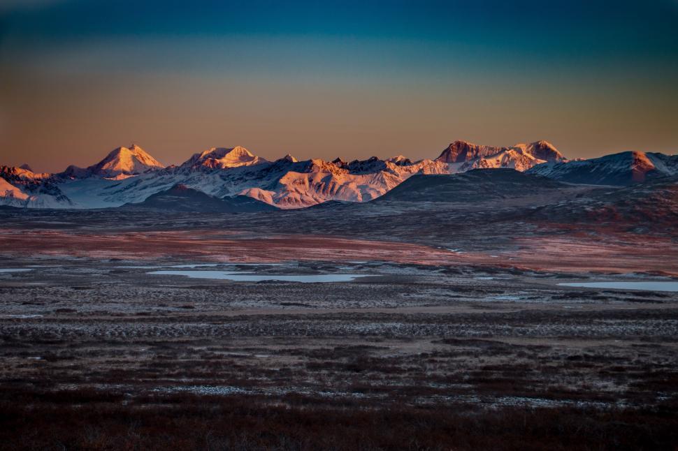 Free Image of Majestic Mountain Range Silhouetted Against Sunset Sky 