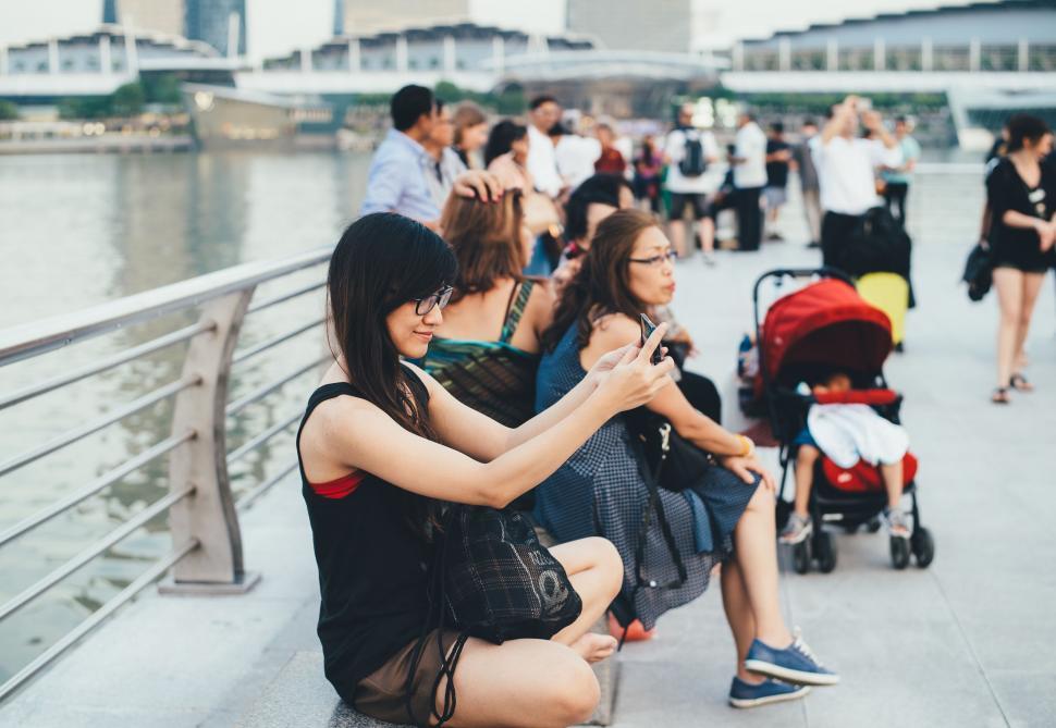Free Image of Group of People Sitting on a Bridge 