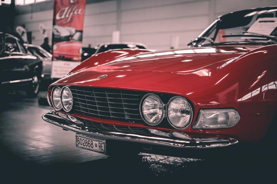 Free Image of Red Car Parked in Garage Next to Other Cars 