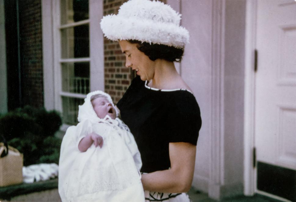 Free Image of Woman Carrying Baby in White Blanket 