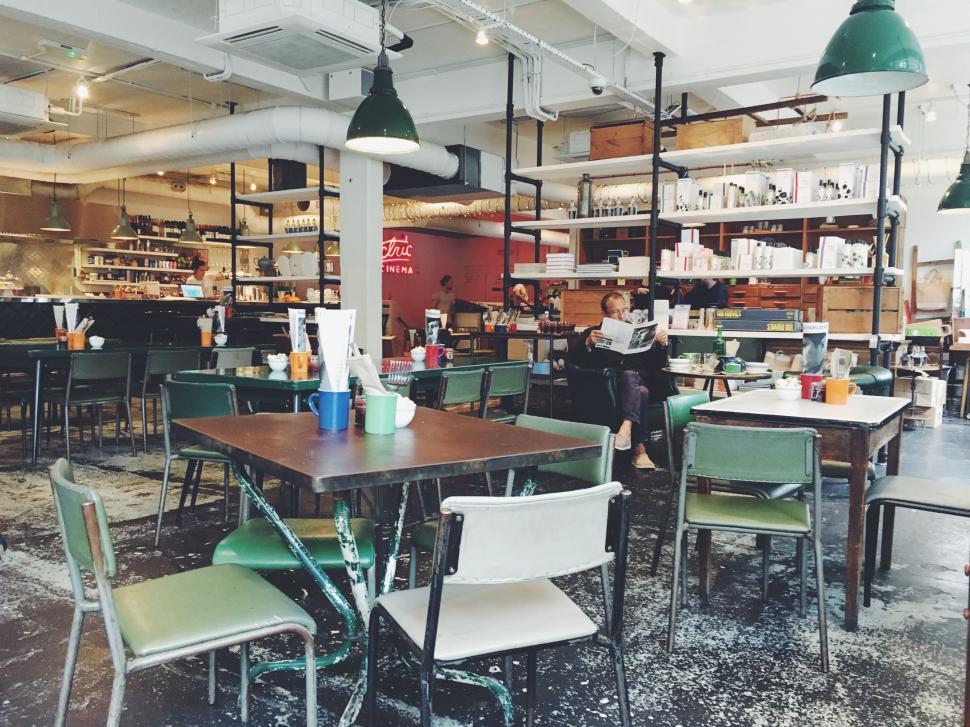 Free Image of Restaurant With Tables, Chairs, and Shelves Filled With Books 