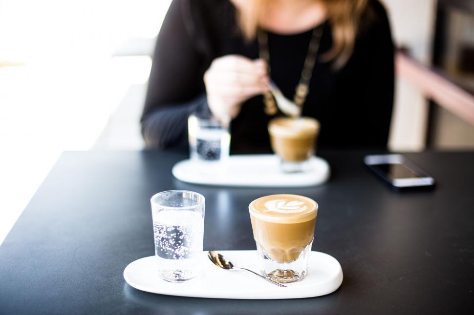 Free Image of Woman Sitting at Table With Cup of Coffee 
