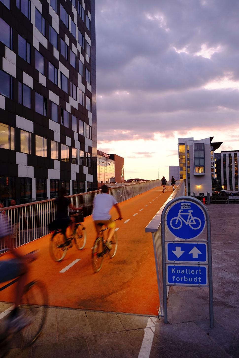 Free Image of Couple Riding Bikes Down Street 