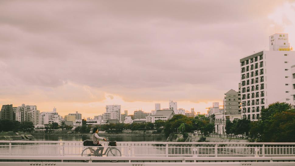 Free Image of Person Riding a Bike Across Bridge 