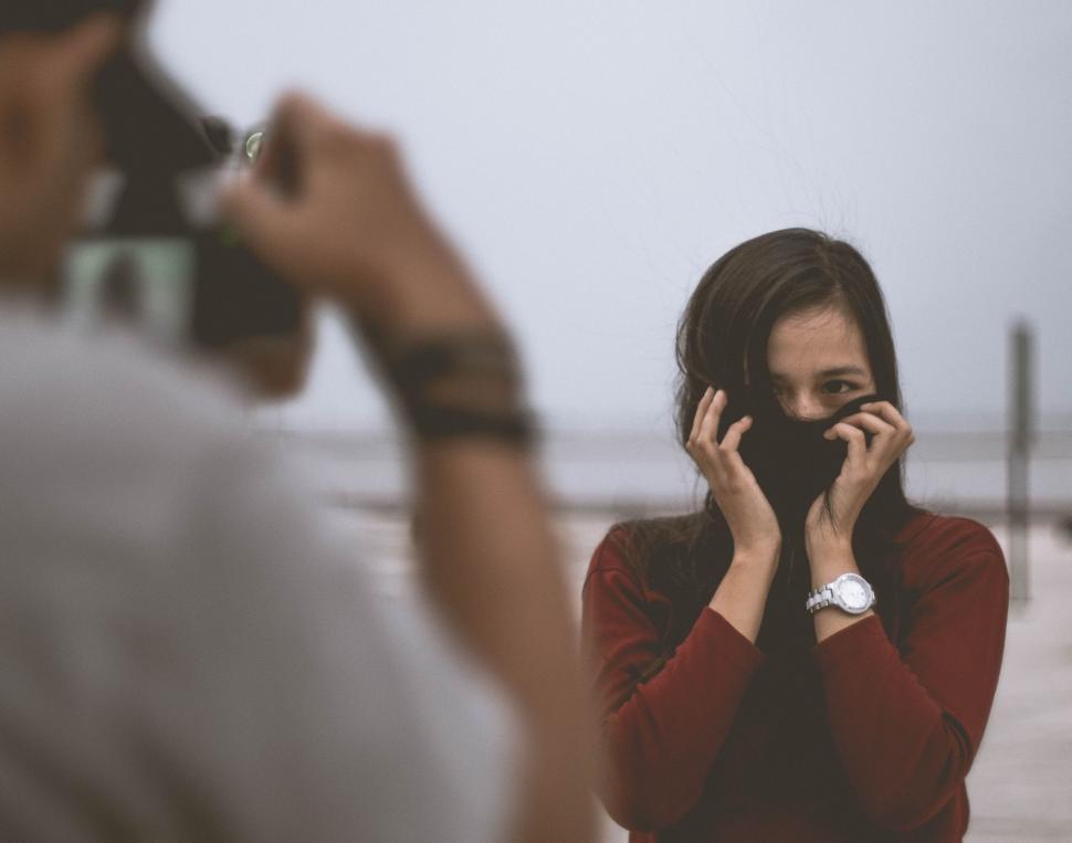 Free Image of Woman Talking on Cell Phone in Front of a Man 