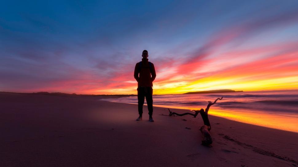 Free Image of Man Standing on Top of Beach Next to Ocean 