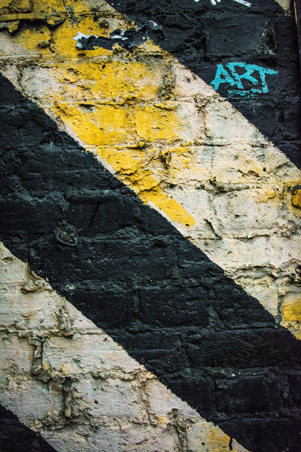 Free Image of Black and White Striped Sign on Brick Wall 