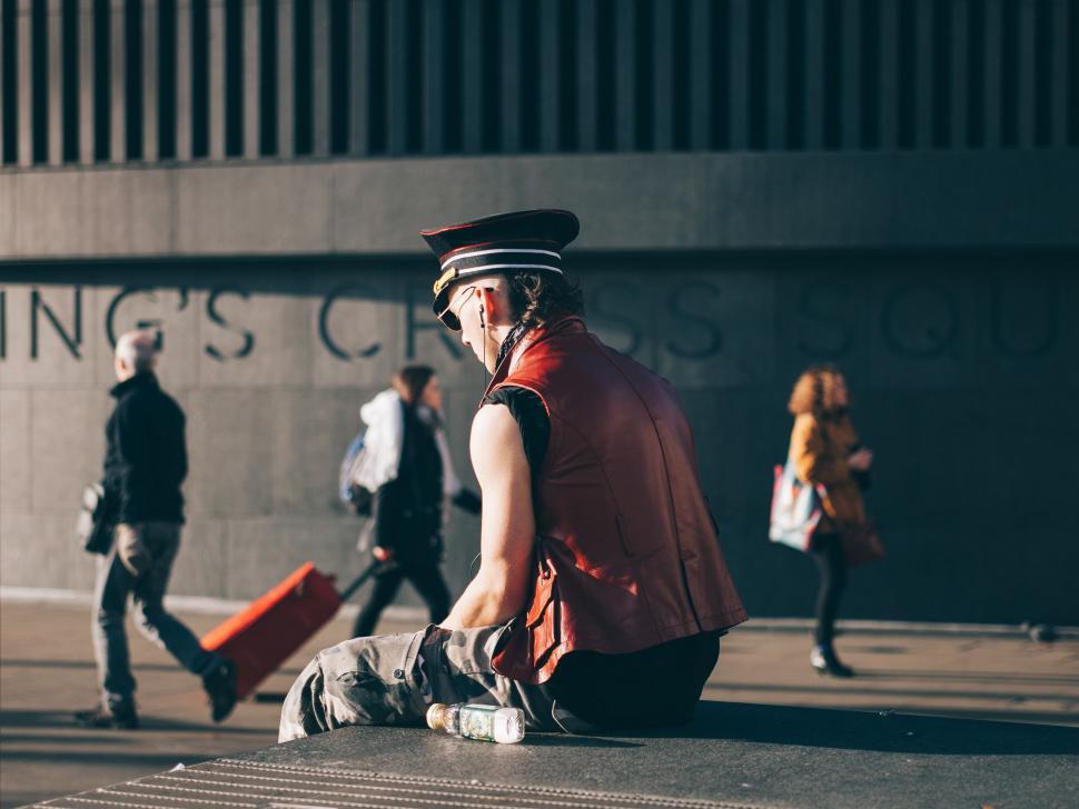 Free Image of Man Sitting on Ground With Luggage 