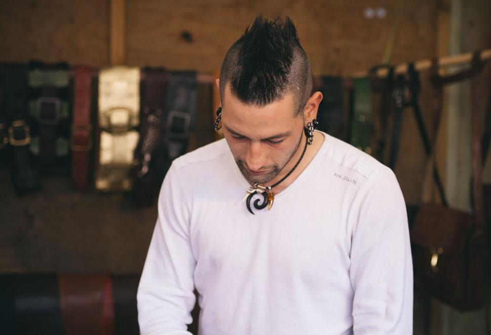 Free Image of Man in White Shirt Cutting Piece of Wood 