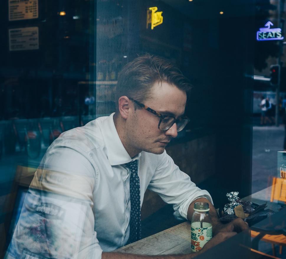 Free Image of Man Sitting at Table in Front of Window 