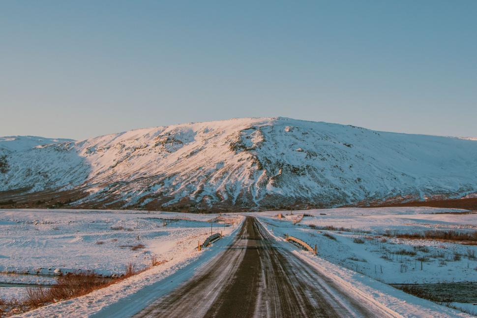 Free Image of Snow Covered Road With Mountain in Background 