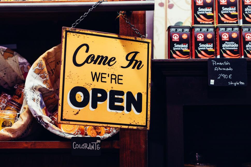 Free Image of Yellow Sign Hanging From Side of Store 