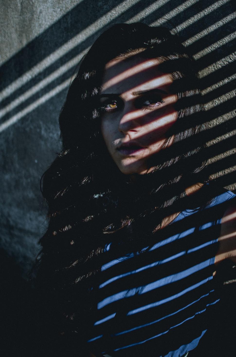 Free Image of Woman Standing in Front of a Striped Wall 