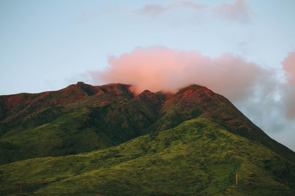 Free Image of Mountain Covered in Green Grass Under Cloudy Sky 